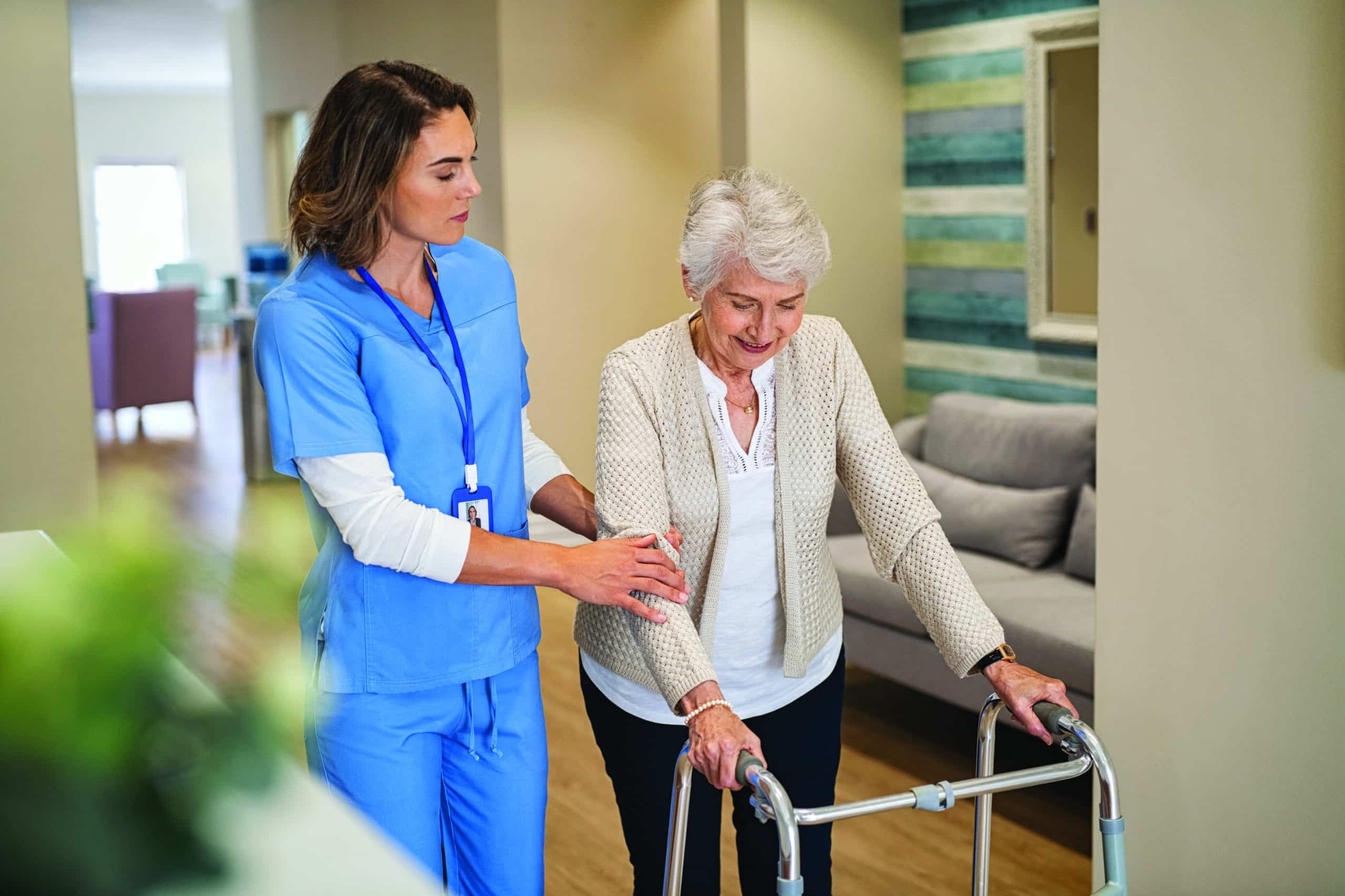 Nurse helping senior woman to walk at private clinic